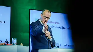 Bundeskanzler Merz zeigt auf einen Gesprächsteilnehmer