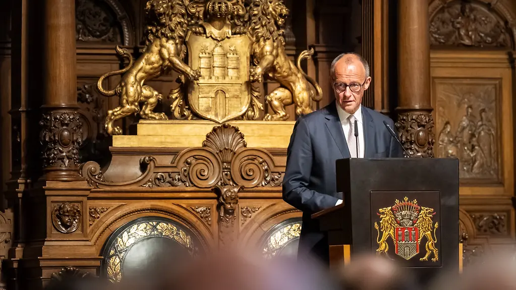 Kanzler Merz am Rednerpult beim Überseetag im Hamburger Rathaus