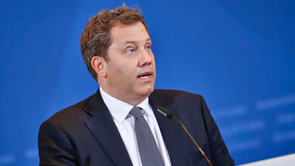 Bundesminister Lars Klingbeil sitzend vor einer blauen Wand. Vor ihm ein Mikrophon.