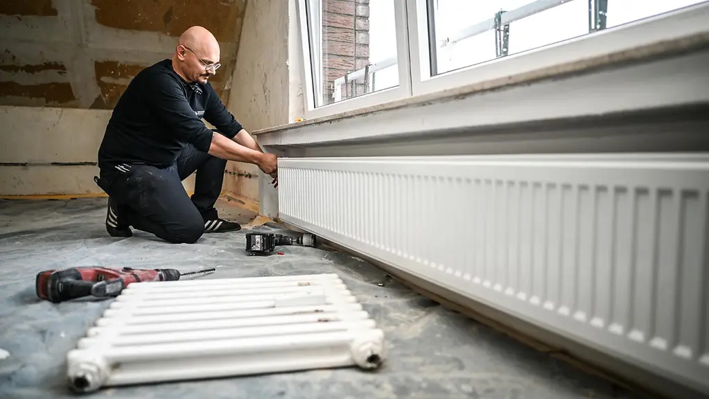 Auf einer Baustelle wird eine neue Heizung eingebaut. 