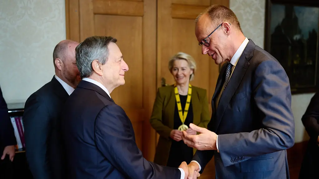 Chancellor Merz with Charlemagne Prize winner Mario Draghi and EU Commission President Ursula von der Leyen in the background
