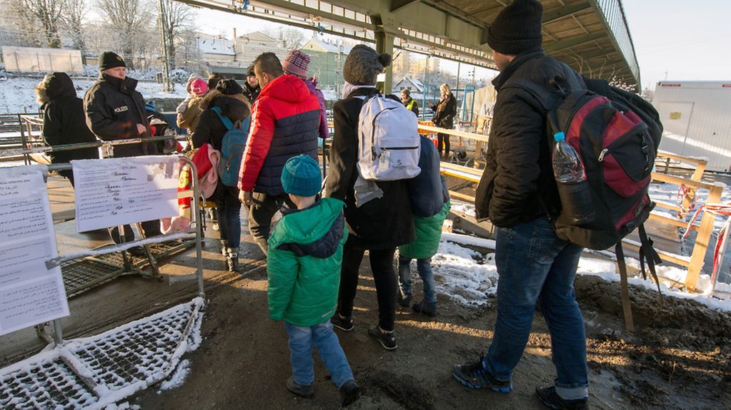 Flüchtlinge gehen am 16.01.2016 am Bahnhof in Passau (Bayern) zu einem Sonderzug, der nach Düsseldorf fährt. Foto: Armin Weigel/dpa