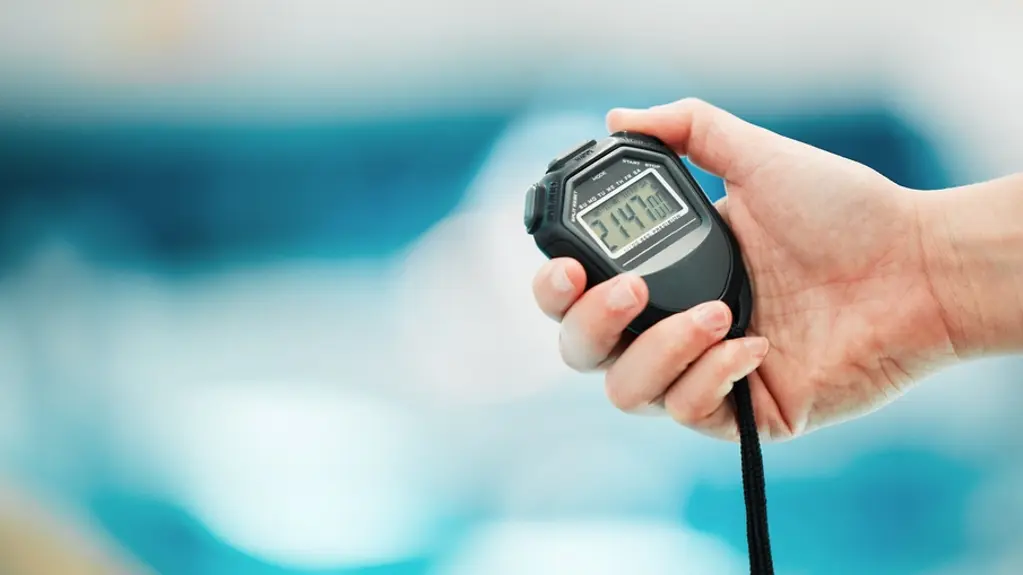 Stoppuhr vor einem Schwimmbecken
