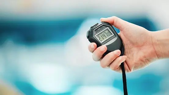 Stoppuhr vor einem Schwimmbecken