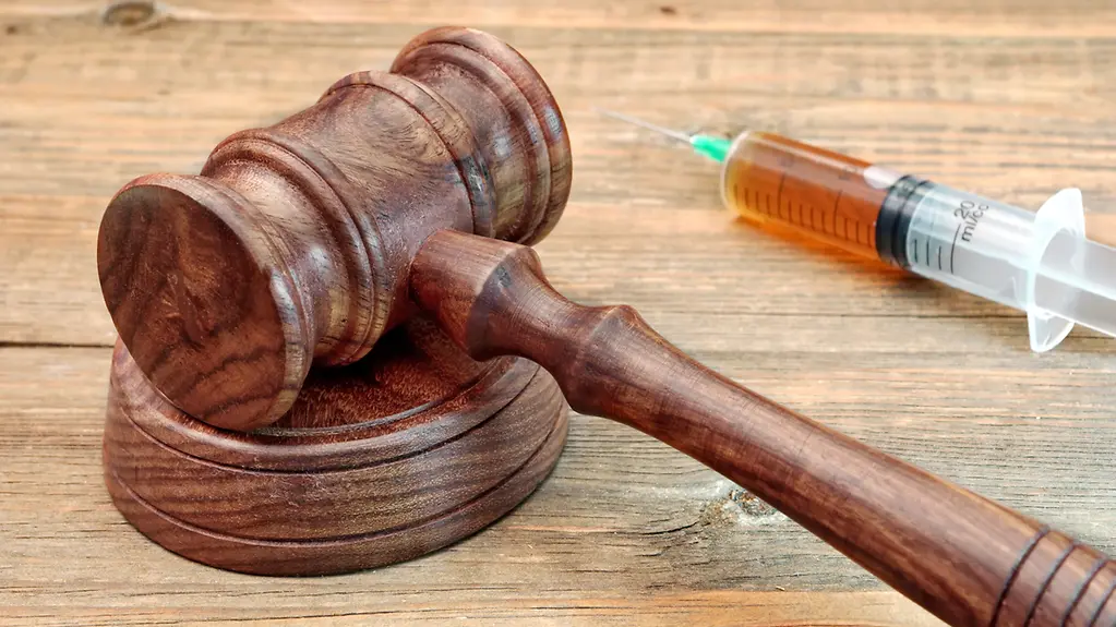 Hammer auf Richtertisch mit Spritze