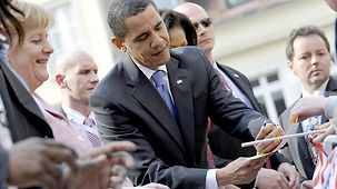 US-Präsident Barack Obama schreibt auf dem Marktplatz in Baden-Baden Autogramme.