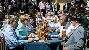 Bundeskanzlerin Angela Merkel und US-Präsident Barack Obama sitzen bei einem Besuch der Gemeinde Krün bei einem bayerischen Frühstück.