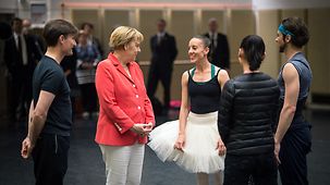 Bundeskanzlerin Angela Merkel unterhält sich mit Balletttänzern.