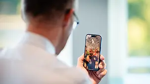 Bundeskanzler Friedrich Merz mit Handy.