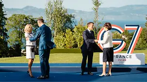 Das Ehepaar Merz wird von Frankreichs Präsident Emmanuel Macron und dessen Frau Brigitte begrüßt.