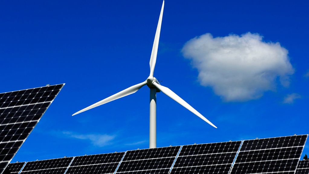 Silizium-Solarzellen eines Sonnenwärmekraftwerks vor einer Windturbine. Windkraft, Solarenergie, Windrad, Photovoltaik