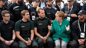 Nach der Pressekonferenz besucht die Kanzlerin Sicherheitskräfte, die während des Gipfels im Einsatz waren.