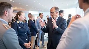 Bundeskanzler Friedrich Merz im Gespräch mit Sportlerinnen und Sportlern bei einem Empfang im Bundeskanzleramt.