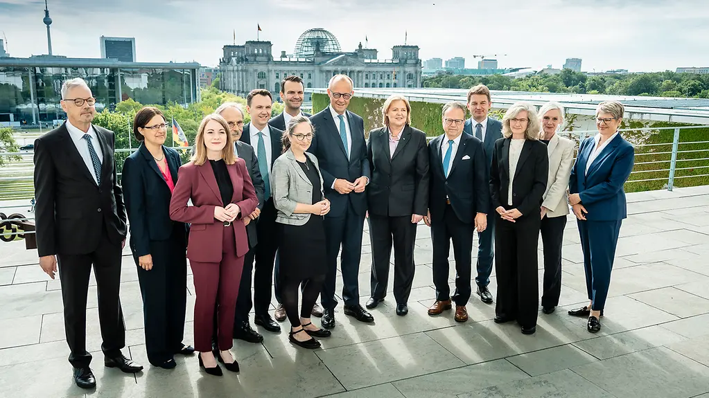 Bundeskanzler Merz und Bundesarbeitsministerin Bas mit der Alterssicherungskommission auf der Terrasse des Bundeskanzleramtes.