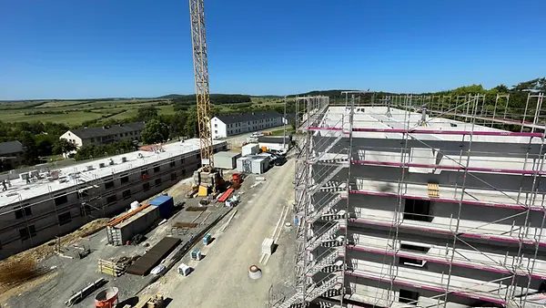 Baustelle mit einem Krahn und einem mehrstöckigen Gebäude.