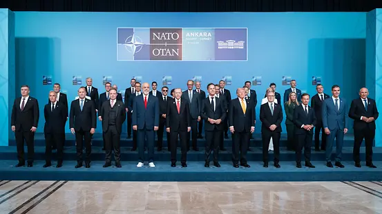 Les 32 chefs d’État et de gouvernement de l’OTAN devant un mur bleu arborant le logo de l’OTAN
