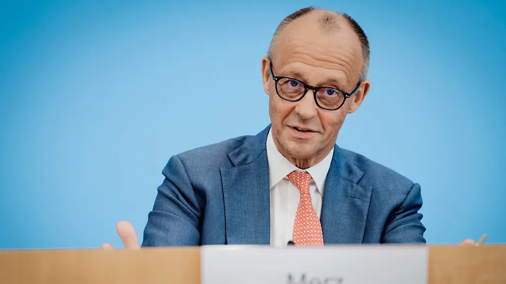 Bundeskanzler Merz vor blauer Wand in der Bundespressekonferenz.
