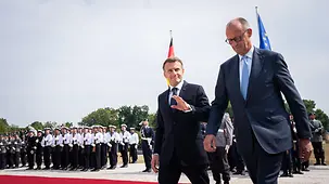 Friedrich Merz et Emmanuel Macron passant en revue le détachement d’honneur
