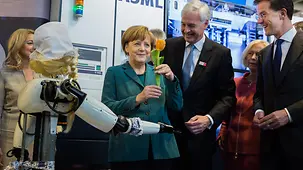 La chancelière fédérale sur le stand « Holland High Tech », à côté du robot « Frau Antje »
