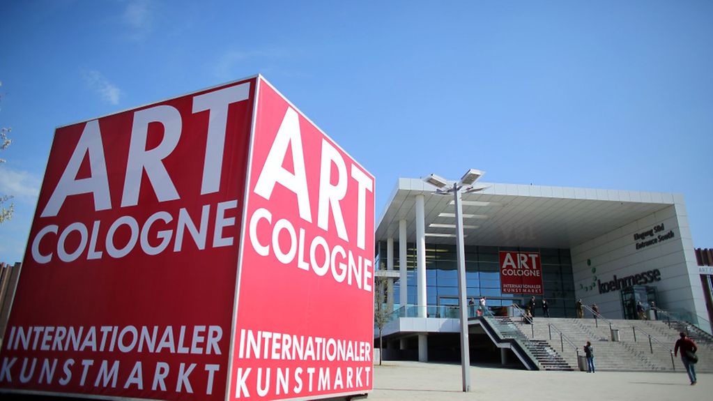 Ein überdimensionaler Würfel mit dem Schriftzug 'Art Cologne' steht in Köln (Nordrhein-Westfalen) vor der Messehalle.