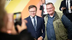 Bundesumweltminister Carsten Schneider posiert im Dialogfoto für ein Foto mit einem Besucher.