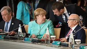 Chancellor Angela Merkel exchanges a word with French President Emmanuel Macron at the G7 summit in Taormina.