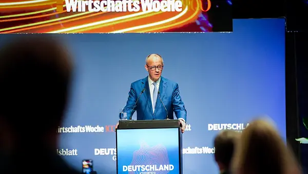 Bundeskanzler Merz am Pult auf der Bühne
