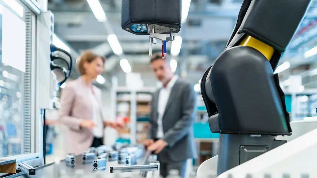 Geschäftsleute mit Robert in einer modernen Fabrik