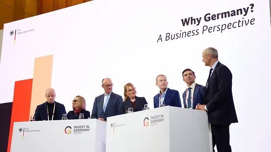 Bundeskanzler Merz beim Investitionsgipfel mit Gästen auf der Bühne