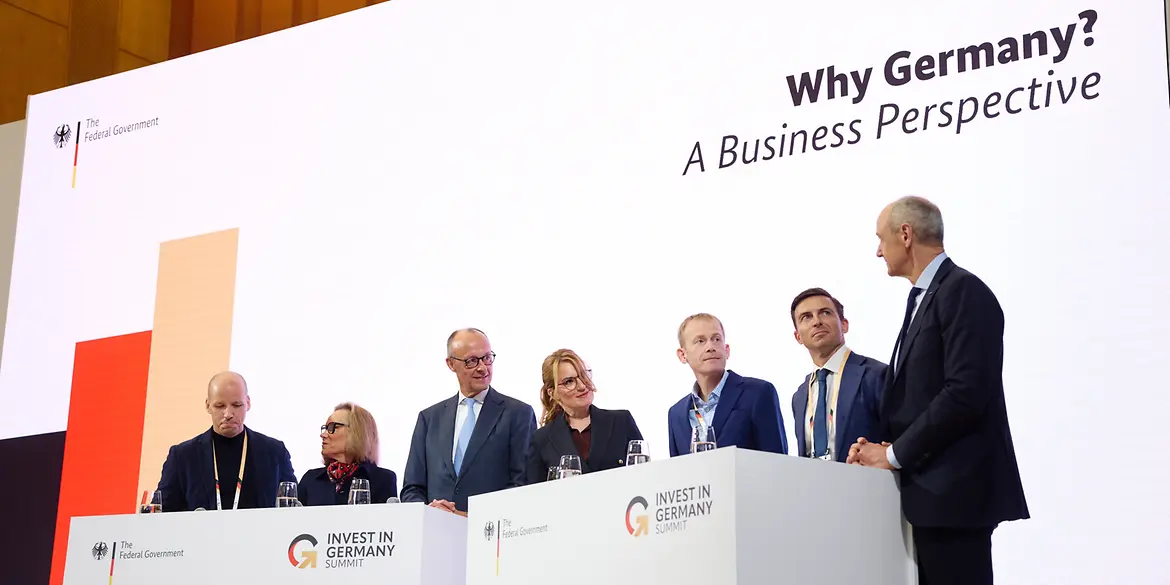 Federal Chancellor Merz on stage with guests at the investment summit