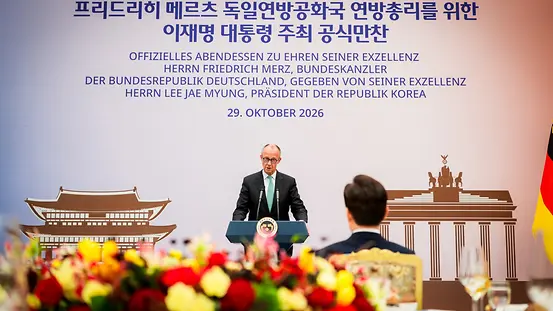 Budneskanzler Merz auf dem Podium hinter einem Rednerpult in Seoul, Südkorea.