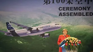 Merkel am Rednerpult vor einem Bild des Airbus.