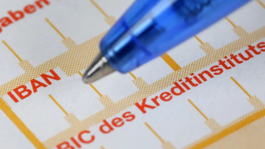 Ein Kugelschreiber neben einem Überweisungsträger mit den Schriftzügen 'IBAN' und 'BIC'