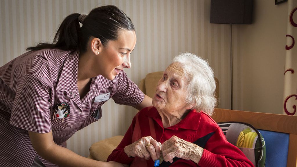 Pflegefachkraft mit einer Seniorin im Pflegeheim