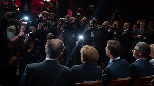 Chancellor Angela Merkel and Dutch Prime Minister Mark Rutte face a battery of photographers.