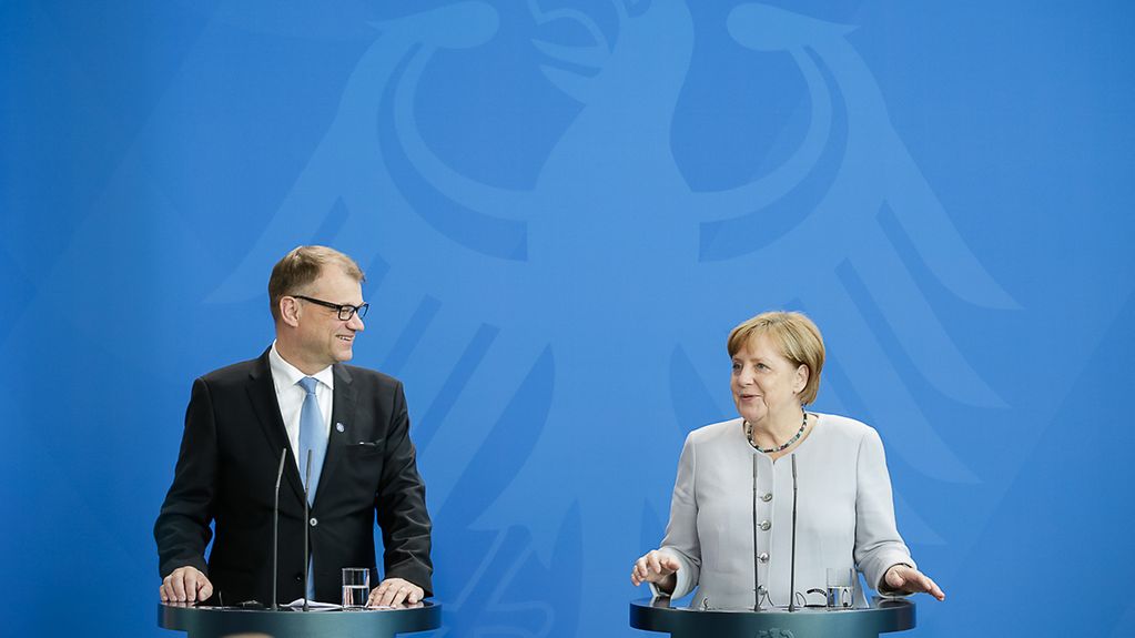 Chancellor Angela Merkel beside Finland's Prime Minister Juha Sipilä at a press conference