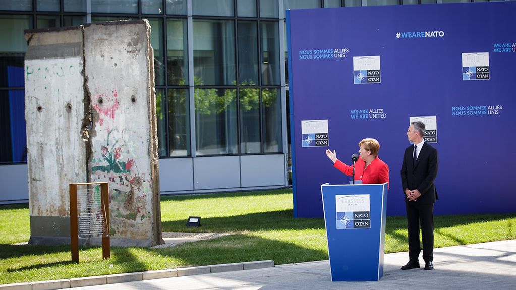 Chancellor Angela Merkel speaks at the unveiling of the Berlin Wall Monument in Brussels; beside her NATO Secretary General Jens Stoltenberg.