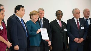 Bundeskanzlerin Angela Merkel (3.v.l.) erhält von Wissenschaftlerinnen und Wissenschaftler der G20-Staaten ein Kommuniqué zur Verbesserung der Gesundheitsversorgung während des G20-Dialogforums 'Wissenschaft Science 20' in der Leopoldina in Halle.