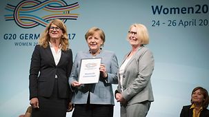 Bundeskanzlerin Angela Merkel (M. mit Communiqué) mit Mona Küppers, Vorsitzende des Deutschen Frauenrates (r.) und Stephanie Bschorr, PrÃ¤sidentin des Verbandes Deutschen Unternehmerinnen e.V. (l.), im Rahmen des W20-Summit.
