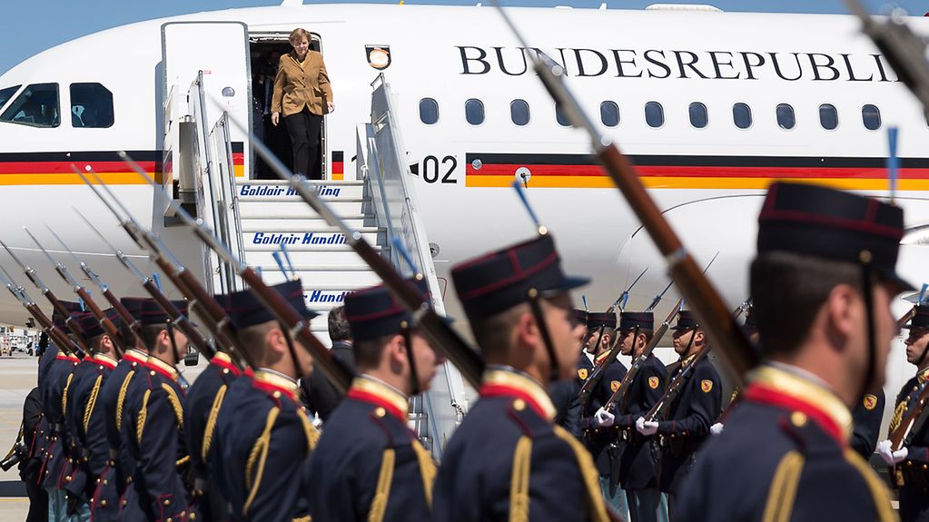Bundeskanzlerin Angela Merkel wird auf dem Flughafen empfangen als sie aus der Regierungsmaschine steigt.