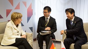 Chancellor Angela Merkel talks to Japan's Prime Minister Shinzo Abe.