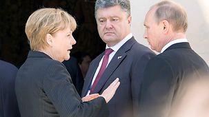 Bundeskanzlerin Angela Merkel im Gespräch mit Russlands Präsident Putin und dem ukrainischen Präsidenten Poroschenko.