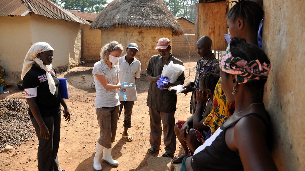 Ärztin mit Einwohnern eines afrikanischen Dorfes.