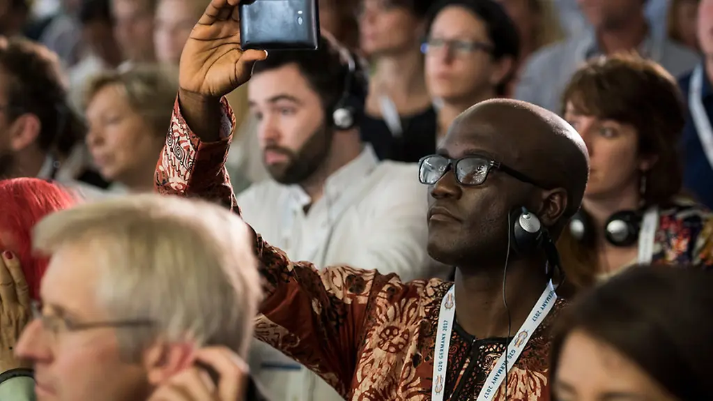 One summit participant films the panel discussion with his mobile.