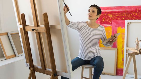 Malerin vor Leinwand in ihrem Atelier