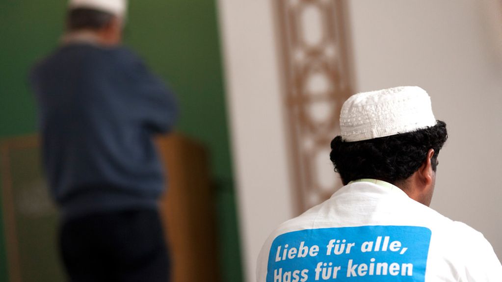 Männer in der Moschee, einer trägt ein T-Shirt: 'Liebe für alle, Hass für keinen'