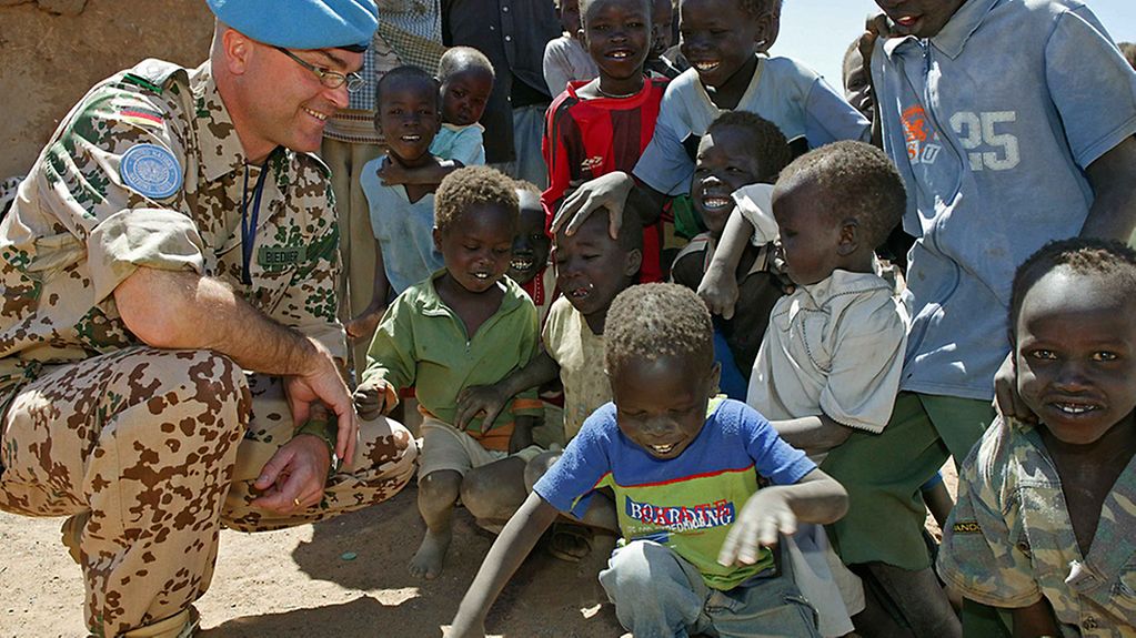 Ein Oberstleutnant mit Kindern in einem Flüchtlingslager im Sudan