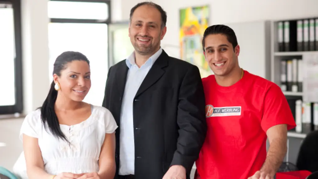 Khalife Rima. Auszubildene (Kauffrau fuer Buerokommunikation, links) und Moussa Sefeddin (Siebdrucker, rechts) und Dipl.-Ing. Omar Halabi (Firmeninhaber, Mitte) bei der Firma H.F. Werbung in Berlin