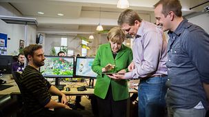 Bundeskanzlerin Angela Merkel und Geschäftführer Jens Begemann am Tablet-Computer.