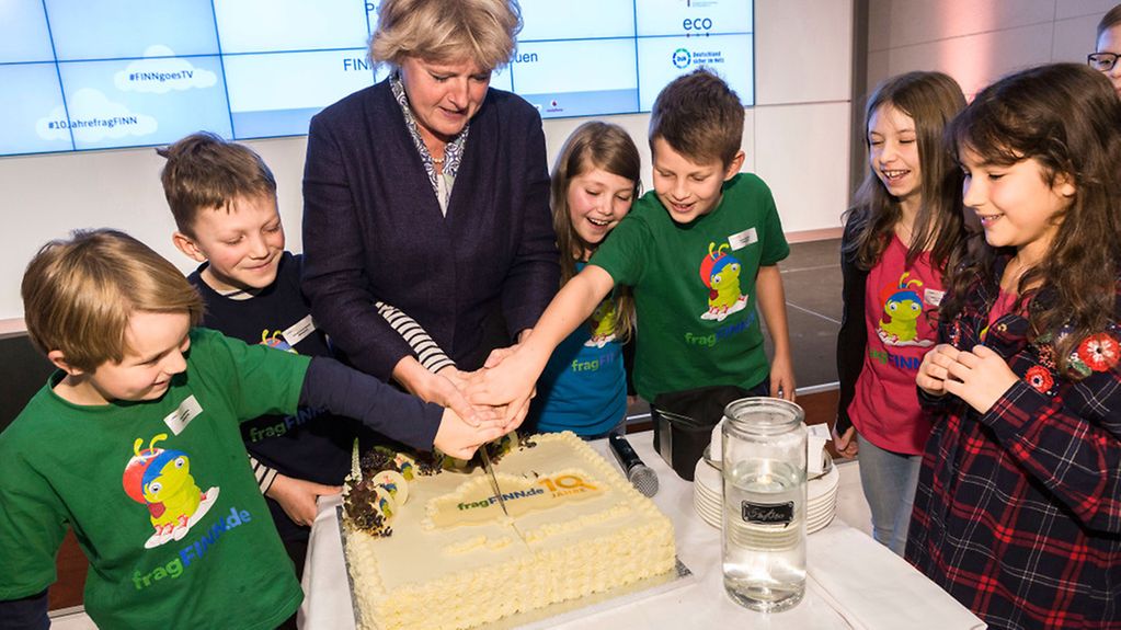 Kulturstaatsministerin Grütters und Kinder schneiden eine Torte an.